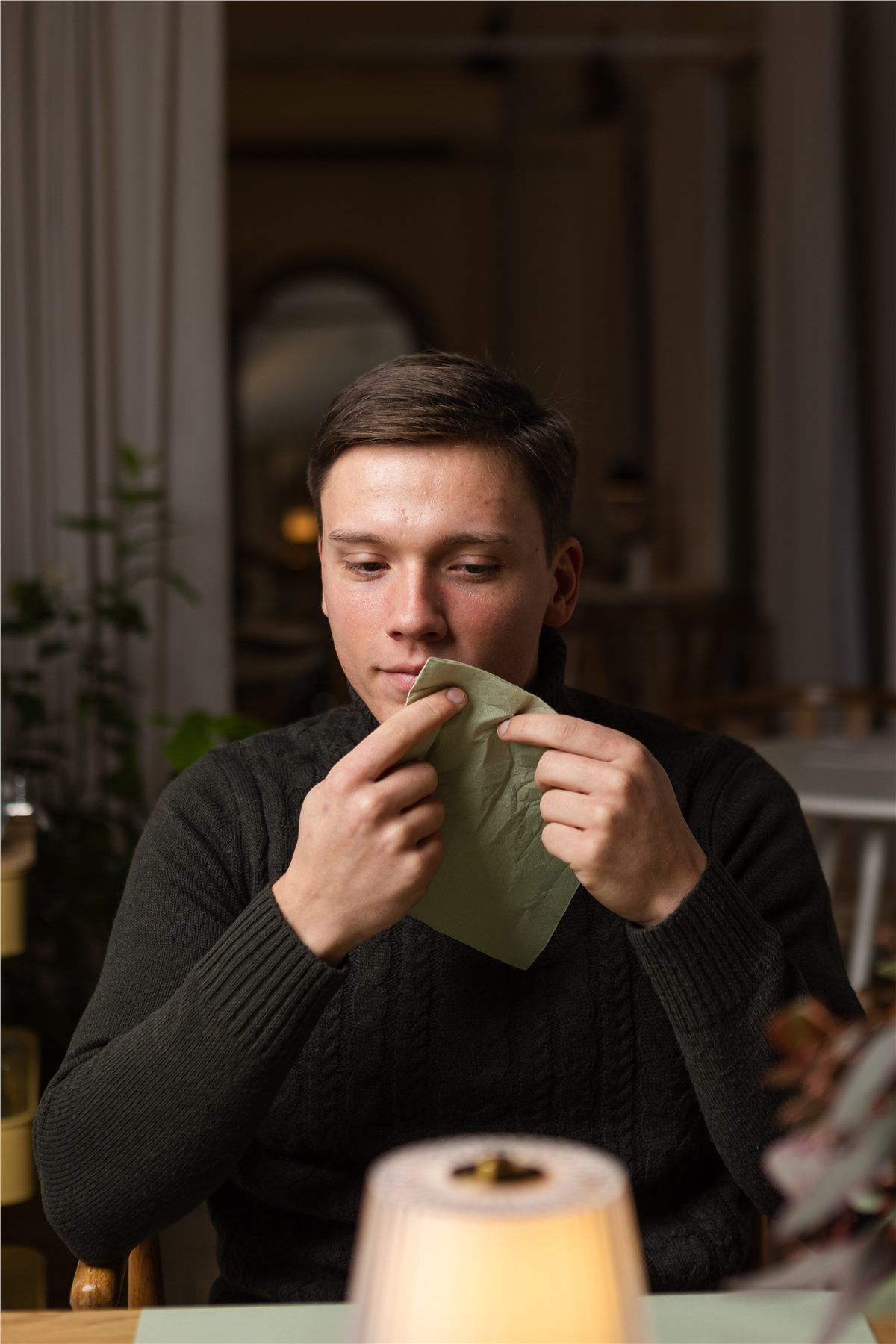 Guest with a soft green napkin in a warmly lit dining room