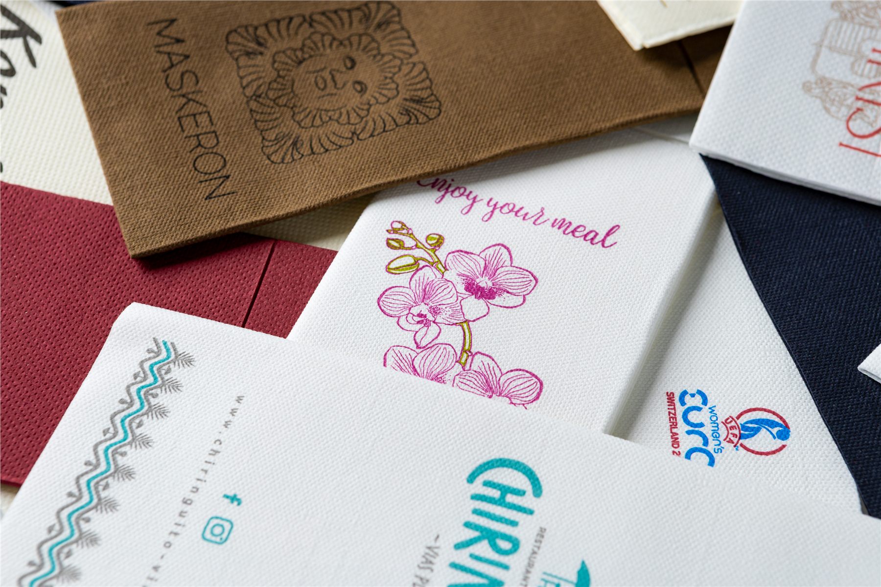 Close-up of logo-printed napkins in brown, white and navy