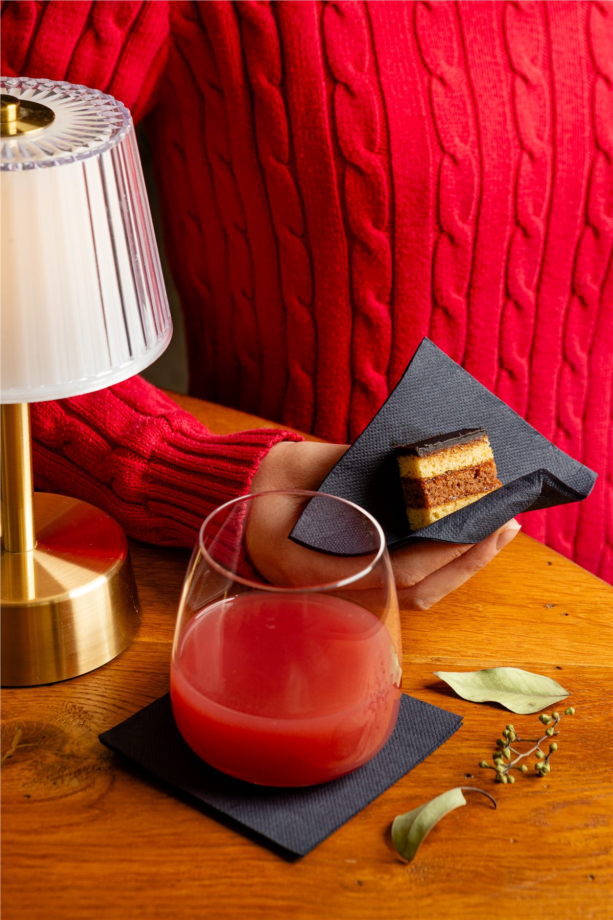 Guest holding a slice of cake on a black cocktail napkin