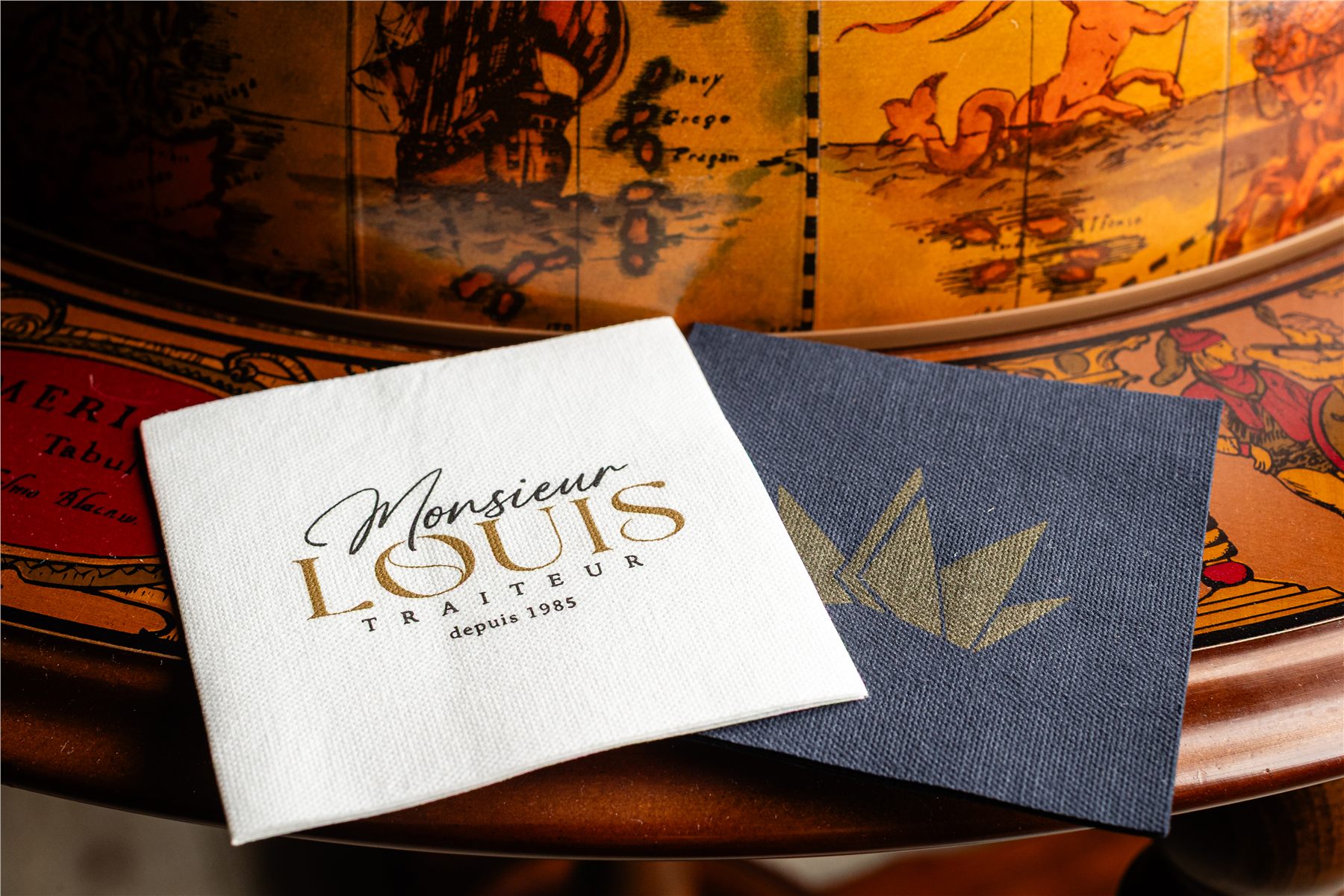 Two logo-printed napkins on a restaurant side table